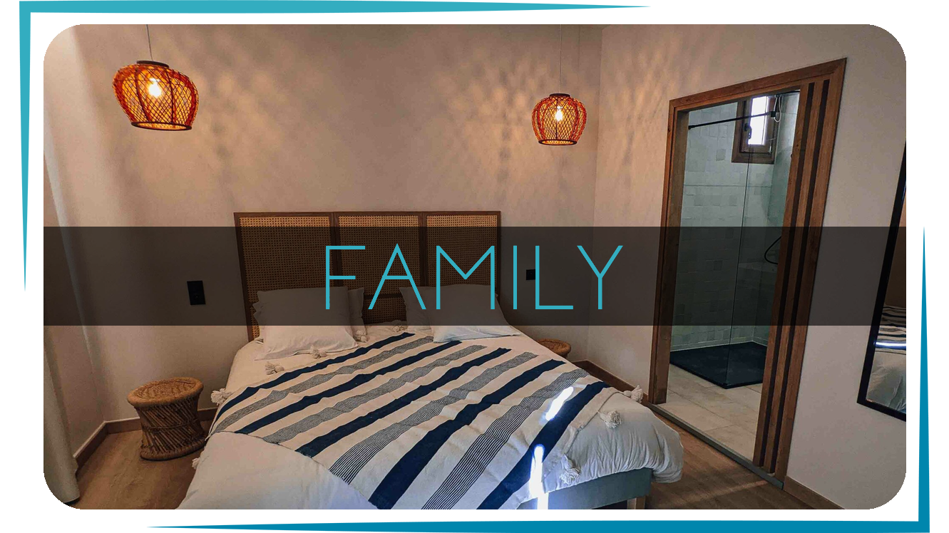 Chambre Famille de l'Intense Boutik Hôtel : lit King Size à tête de lit en cannage et salle d'eau